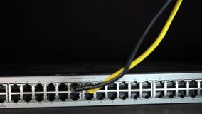 Professional close-up shot showing a technician’s hand connecting an ethernet cable into a network switch inside a server rack. The frame highlights multiple ports, active cabling, and the precise moment of plugging in the connector, representing network setup and maintenance work. Shallow depth of field keeps the focus on the connection point while the surrounding hardware softly fades, creating a clean and technical atmosphere. Perfect for topics such as data center operations, IT support, cybersecurity infrastructure, cloud services, system administration, troubleshooting, and enterprise networking. Ideal for technology blogs, corporate presentations, training materials, and promotional content related to connectivity, uptime, and modern digital systems. - Powered by Shutterstock - Get 15% off with code: PIKWIZARD15