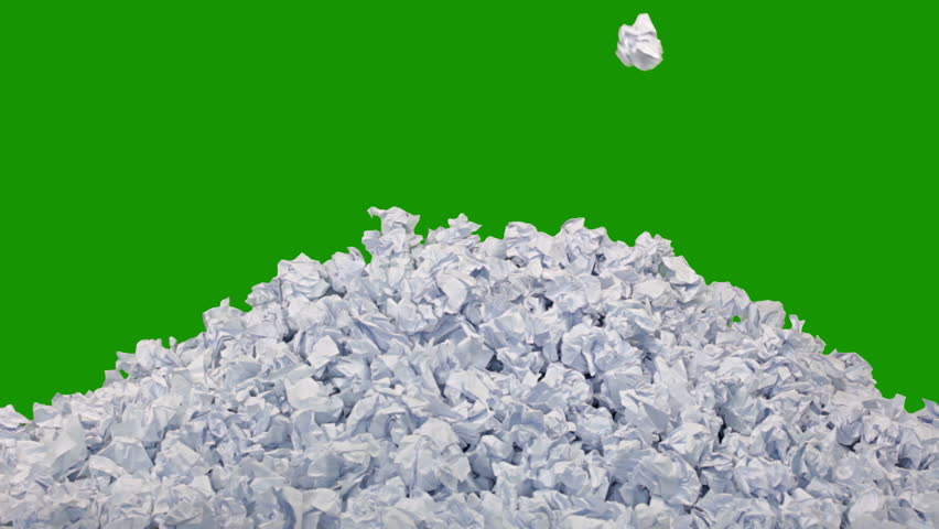 Green background (Chroma Key). New crumpled paper ball are added to the heap one