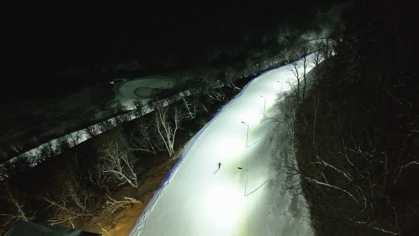 Aerial night view of illuminated ski slopes at Crystal Ski Arena in Bakuriani, Georgia.
