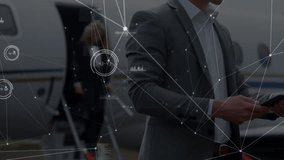 Businessman in suit bringing device and tapping, network HUD overlaying jet while monitoring data. Aviation, ramp, executive, touchscreen, travel, overcast, tarmac - Powered by Shutterstock - Get 15% off with code: PIKWIZARD15