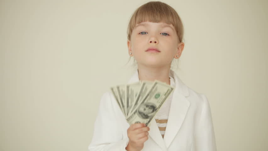 Little girl holding dollars in her hand and waving their
