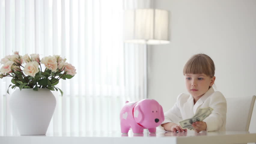 Little girl with piggy bank and with money
