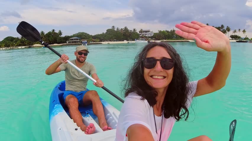 POV Couple take selfie enjoy Kayaking activity on turquoise tropical waters. Vacation in Maldives. Fulidhoo island coastline and sports activities