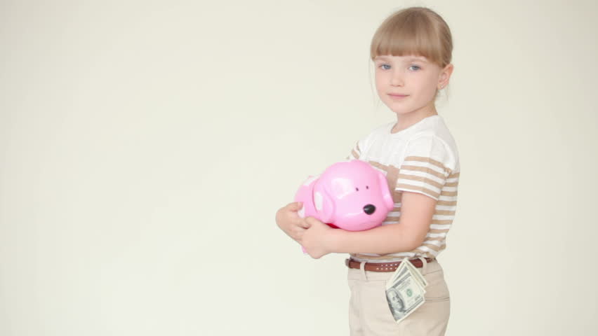 Little girl standing with piggy bank
