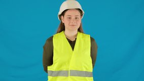 Woman builder in uniform shows power drill on blue background. Smiling young female in uniform playfully demonstrates tool for repair work - Powered by Shutterstock - Get 15% off with code: PIKWIZARD15