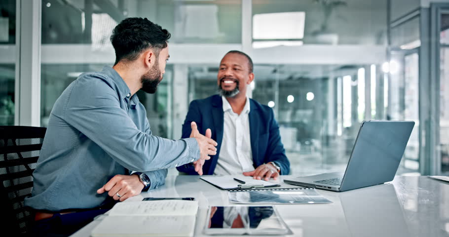 Handshake, meeting and business men in office with paperwork for finance deal, agreement or merger. Smile, team or workers shaking hands for collaboration, corporate partnership or financial contract