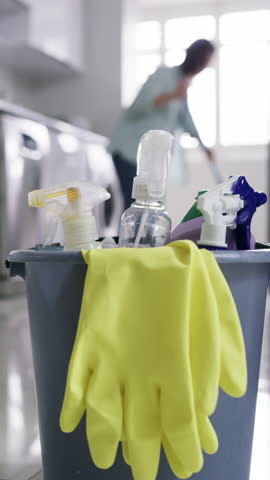 Gloves, cleaning supplies and bucket in home for hygiene, disinfection and household chores. Detergent, spray bottle and materials for tidying with bacteria, germs or dirt removal in apartment.