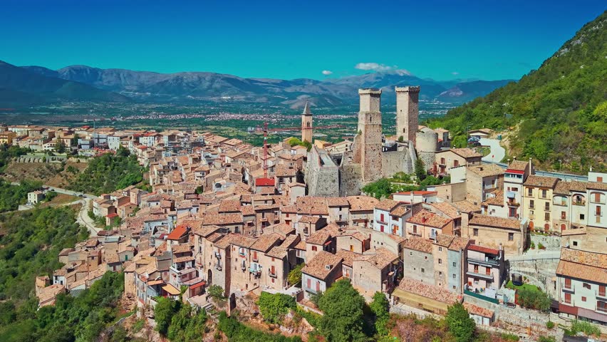 Breathtaking aerial view of Pacentro, one of Italy most beautiful medieval villages. Highlights the iconic square towers of the Caldora Castle (Castello Caldora) and stone houses perched 