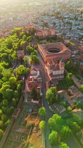 Aerial view of the historic Alhambra palace at sunset in Granada, Andalusia, Spain. The ancient Arabic fortress Alhambra during the beautiful evening. Aerial drone footage of Granada cityscape