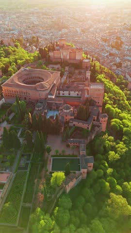 Aerial view of the historic Alhambra palace at sunset in Granada, Andalusia, Spain. The ancient Arabic fortress Alhambra during the beautiful evening. Aerial drone footage of Granada cityscape