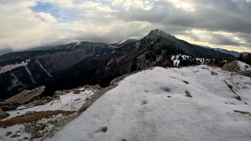 Side Track Shot of a Snowy Rocky Lookout with a View of Winter Panorama and Mountain Peak.