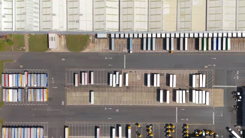 Major distribution hub, semi-trucks and logistics transport of goods and products across the country near Clumber, United Kingdom. Aerial drone view. 