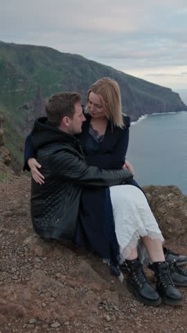 Romantic couple embracing on cliffside at dusk