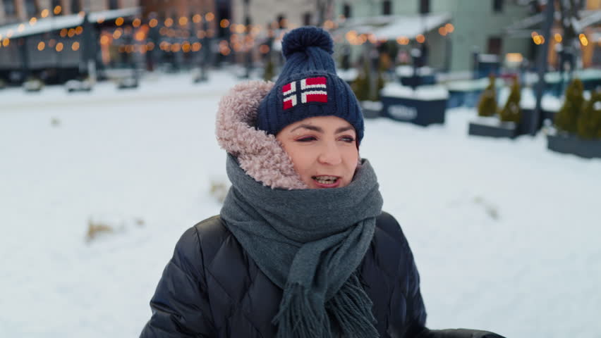 Young lady with winter attire, Woman with joyful expression dressed for cold weather among city lights