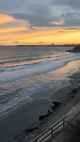 Sandy beach, small waves in the soft, light of the setting sun.