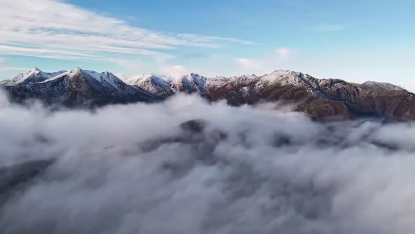 Aerial view of clouds moving over mountain peaks