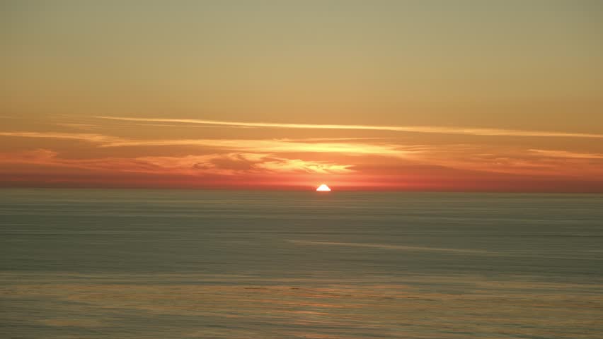 Beautiful orange pink sunset over ocean in San diego California, sun disappearing on the horizon