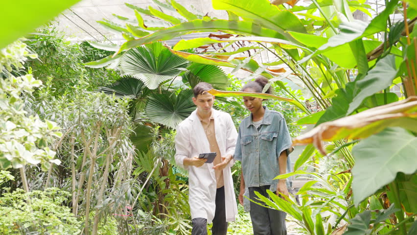 African teenage girl learning plant cultivation with botanist in greenhouse, agriculture education and botany research, sustainable farming, plant science study, environmental ecology technology.