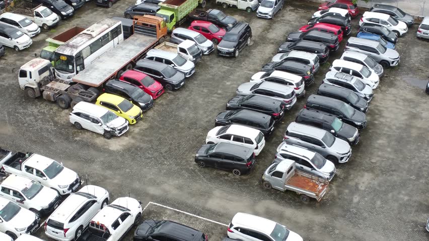 Aerial view of a parking lot lined up with cars for rent