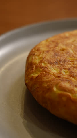 High-resolution photo of a traditional Spanish potato omelette served on a rustic plate. Classic homemade dish widely enjoyed in Spanish bars and households, ideal for food, travel, and lifestyle concepts.
