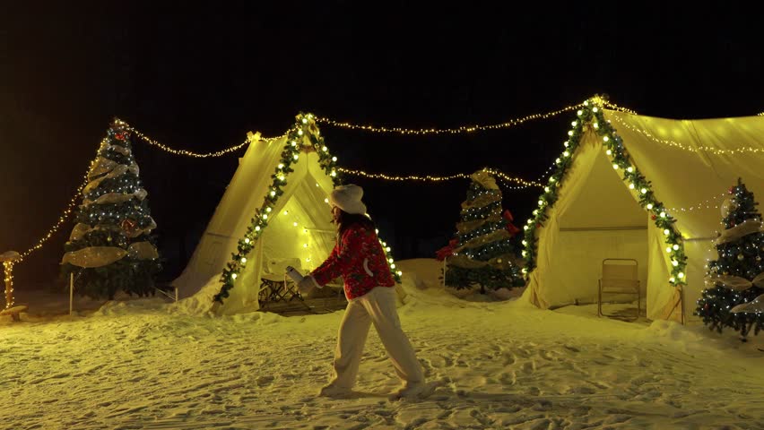Young female tourist splashing hot water, turning it into steam in the freezing cold air at Harbin in China