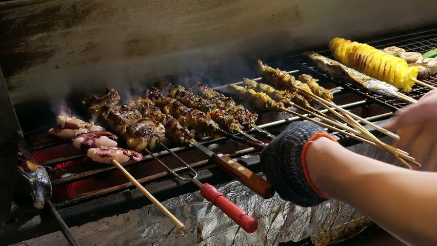 late-night food stall grilling lamb skewers and lamb chops and squid and potato tornado and other delicacies