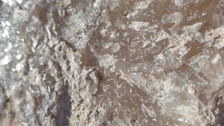 A detailed close-up of raw barite rock revealing each distinctive formation and texture; set in an authentic environment to emphasize the mineral natural allure, highlighting its glassy luster.