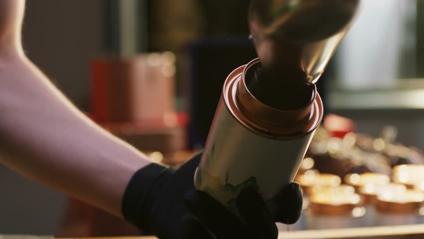 Close-up of hands of worker filling container with tea leaves in factory