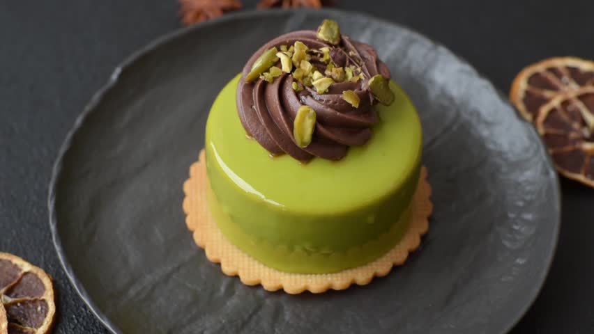 Pistachio cake or tart topped with green mousse with nuts and fruit filling. Pistachio pie as a food background for your design