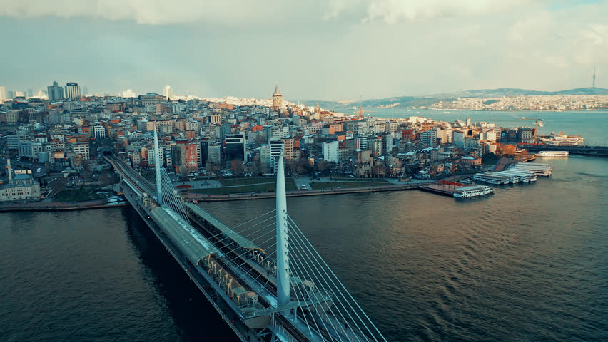 Halic Metro Bridge aerial view of the modern transit bridge over Golden Horn. Cinematic drone flight showing the metro station and Istanbul skyline.