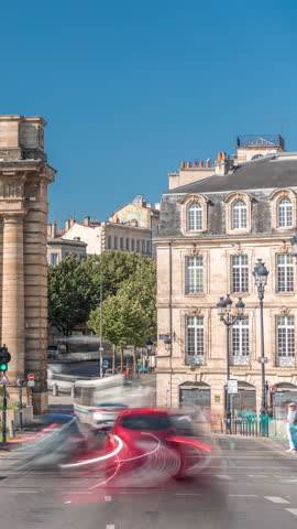 Porte de Bourgogne timelapse hyperlapse, historic medieval gate in Bordeaux, France. Iconic landmark with a triumphal arch, surrounded by classical architecture and streets with trees and busy traffic