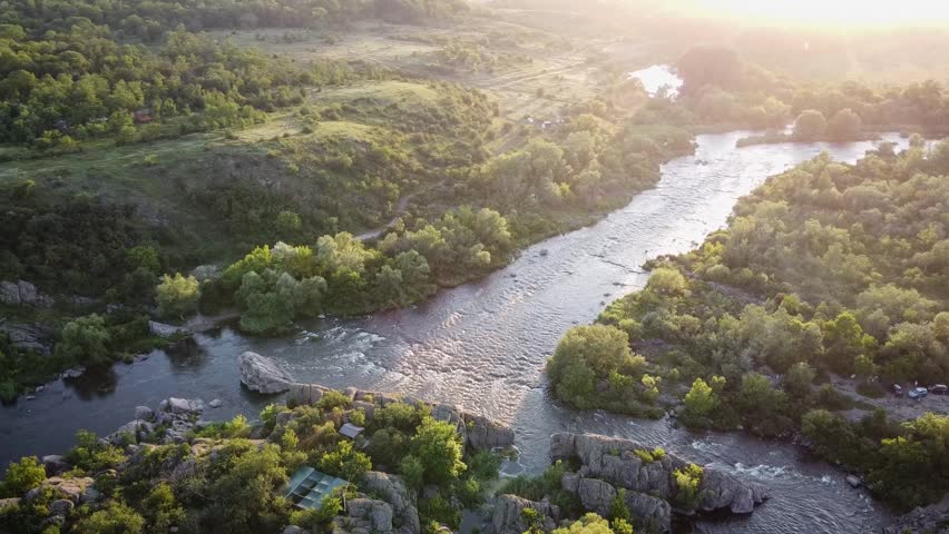 Aerial view of the Southern Bug river with rapids at sunset. Scenic summer landscape of Mygiya rapids in Ukraine during golden hour.