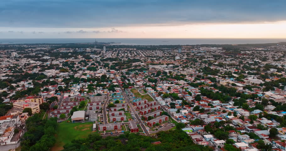 Low-rise urban landscape of modern Puerto Rico. Drone footage over the green city on cloudy day.