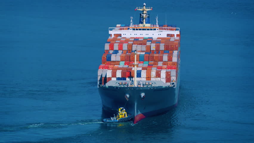 Tug Boats Push Freighter Ship Around