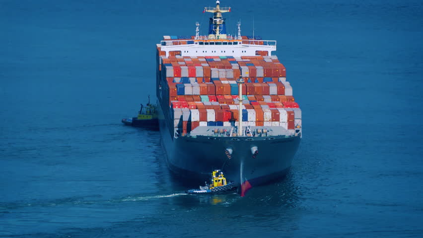 Tug Boats Push Freighter Ship Around