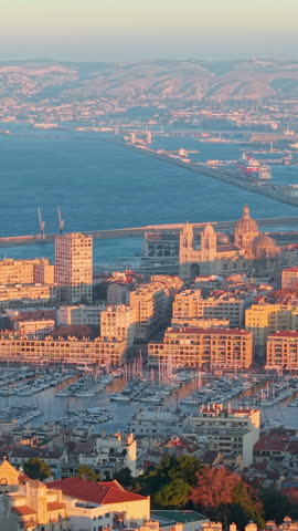 Aerial Vertical Sunset City Harbor Panorama With Sunlit Rooftops, Waterfront Blocks And Distant Port Cranes Warm. Marseille. France