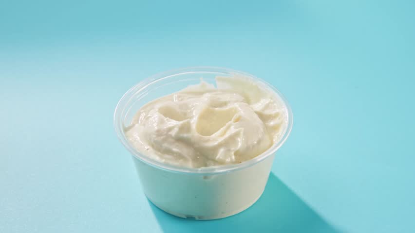 Slow motion of naan tortilla bread appetizer dipping slowly in slo mo macro close-up into a small cup bowl of tasty white garlic sauce before eating healthy fresh food from restaurant meal