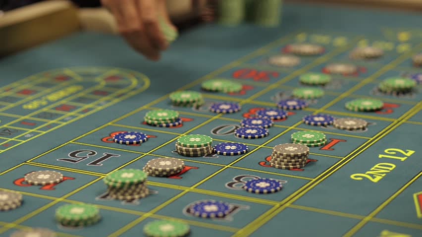 Casino Dealer Dealing Cards at Poker Table with Chips