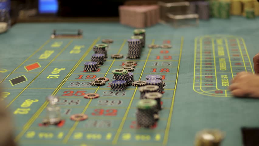 Casino Dealer Dealing Cards at Poker Table with Chips