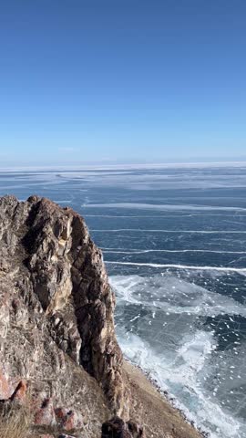 a view from the top of the mountain of the beautiful smooth and cracked ice of Lake Baikal