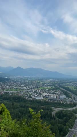 Aerial view of Bregenz, Austria, showing the Rhine Valley, A14 highway, and Lake Constance Includes scenic mountain peaks and international flags at a panoramic lookout   point. 