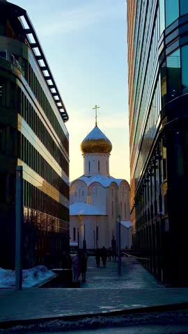 The historic Church of St. Nicholas at Tverskaya Zastava, a symbol of Old Believer tradition, contrasts with modern city architecture under a winter sky in Moscow.