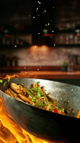 Super Slow Motion of Flying Asian Meal with Meat and Vegetable. Filmed on High Speed Cinema Camera, 1000 fps. Blur Kitchen Interior on Background.