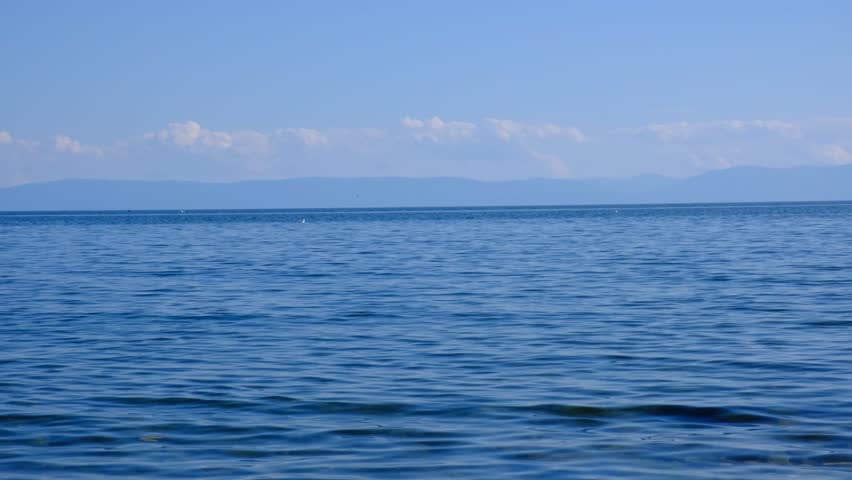 Alone sailboat floating in vast open sea under serene blue sky, tranquil ethereal view, maritime. Dreamy wilderness.