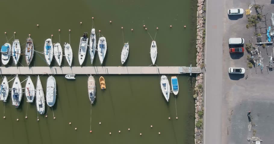Aerial view of Suomenoja Marina, featuring numerous sailboats and yachts docked along a pier in summer, Espoo, Finland.