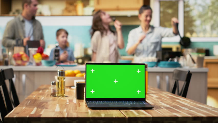 Mockup screen on laptop with cheerful family making homemade pizza, cooking in a cozy kitchen. Parents and kids laugh while adding mozzarella and vegetables, weekend bonding. Camera B.
