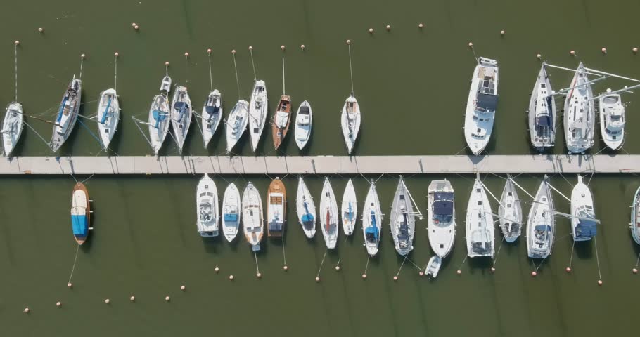 Aerial view of Suomenoja Marina, featuring numerous sailboats and yachts docked along a pier in summer, Espoo, Finland.