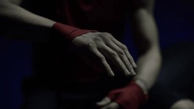 Boxer wrapping injured hands before training or a fight, emphasizing preparation, safety, recovery, athletic discipline, and combat sports. - Powered by Shutterstock - Get 15% off with code: PIKWIZARD15