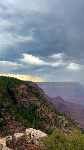 Vertical panning shot of dramatic scenery at the Grand Canyon National Park in Arizona with rain clouds rapidly approaching