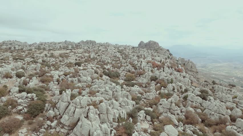 Breathtaking rocky landscape with sparse vegetation under cloudy sky